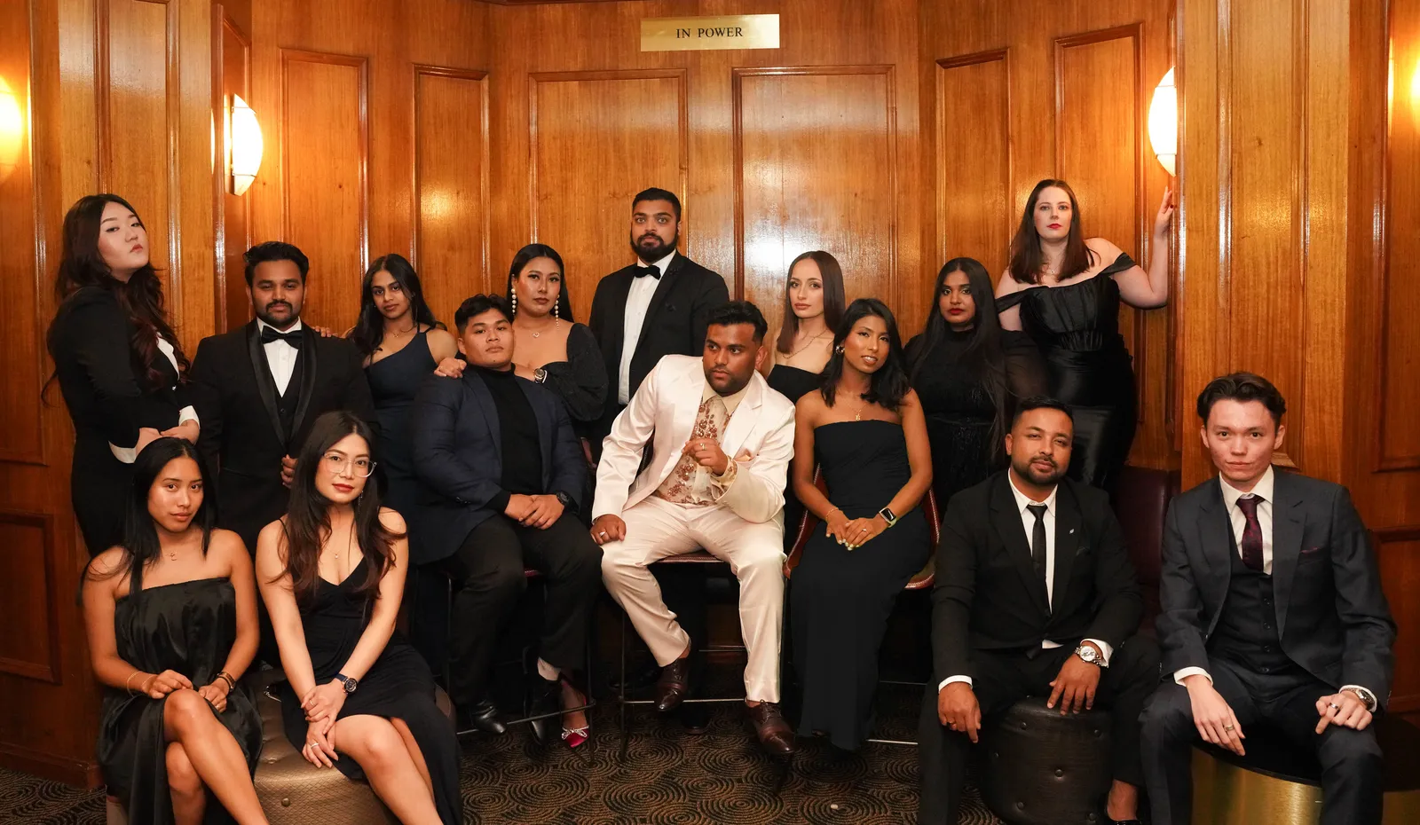 Formally dressed group portrait in a wood-panelled room at a Canberra gala night