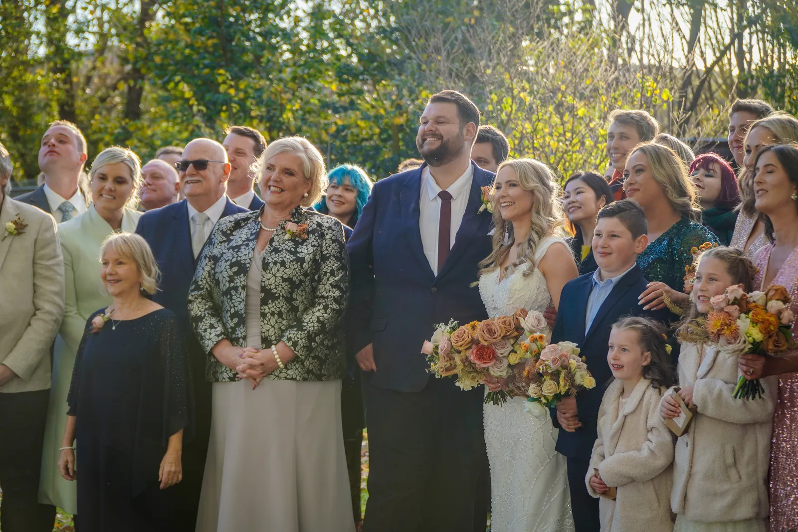 Bride, groom and wedding guests gathered outdoors looking on during a Canberra wedding